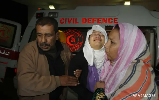 Palestinian men wheel a wounded woman on a stretcher into al-Shifa hospital in Gaza City on December 9, 2011, after an Israeli air strike. Photo by Mahmud Nassar