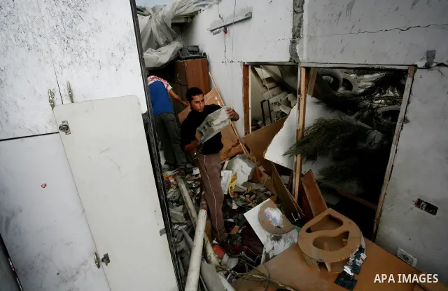 Palestinians inspect a destroyed house in Gaza city on December 9, 2011. Violence across the Israeli-Gaza border escalated on Friday with Israeli air strikes killing at least three people and Palestinian militants firing...