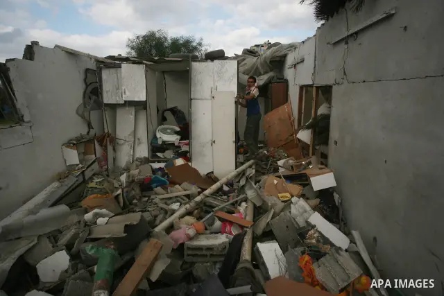 Palestinians inspect a destroyed house in Gaza city on December 9, 2011. Violence across the Israeli-Gaza border escalated on Friday with Israeli air strikes killing at least three people and Palestinian militants firing...