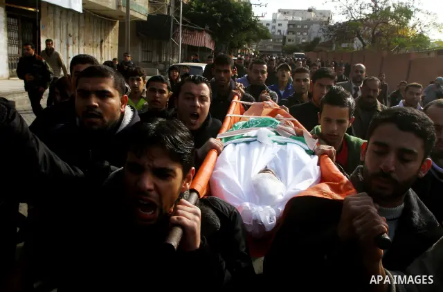 Palestinians carry the body of Bahjat Al-Zalan, who was killed in a blast from an Israeli air strike on a nearby Hamas training camp in Gaza City, during his funeral in Gaza City December 9, 2011. Violence across the Isr...