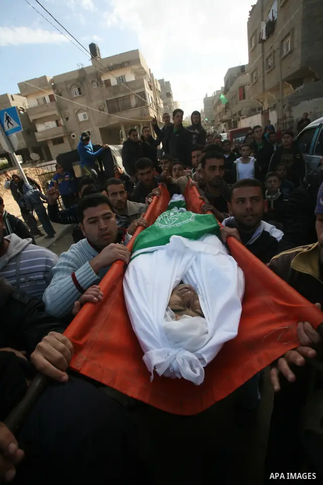 Palestinians carry the body of Bahjat Al-Zalan, who was killed in a blast from an Israeli air strike on a nearby Hamas training camp in Gaza City, during his funeral in Gaza City December 9, 2011. Violence across the Isr...