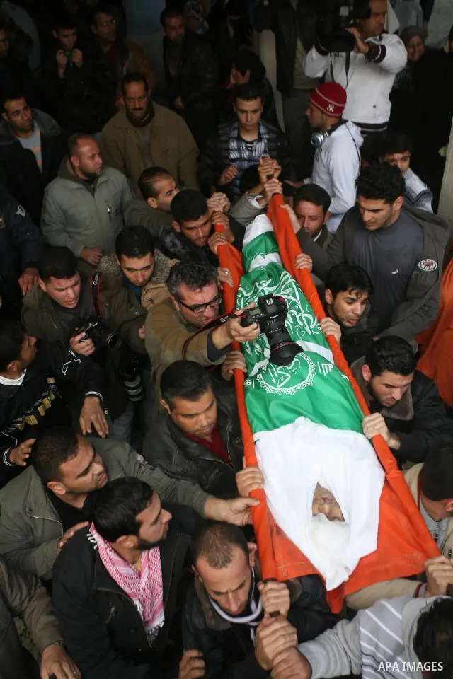 Palestinians carry the body of Bahjat Al-Zalan, who was killed in a blast from an Israeli air strike on a nearby Hamas training camp in Gaza City, during his funeral in Gaza City December 9, 2011. Violence across the Isr...