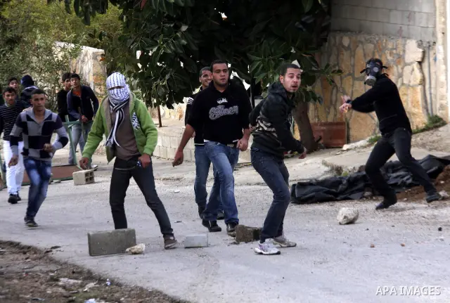 Palestinian protesters throw stones towards Israeli soldiers during clashes that broke out at a weekly demonstration against Israeli-occupation in the northern West Bank village of Kfar Kadum on December 9, 2011. A Pales...