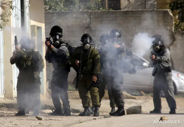 Israeli soldiers fire tear gas towards Palestinian protesters during clashes that broke out at a weekly demonstration against Israeli-occupation in the northern West Bank village of Kfar Kadum on December 9, 2011. A Pale...