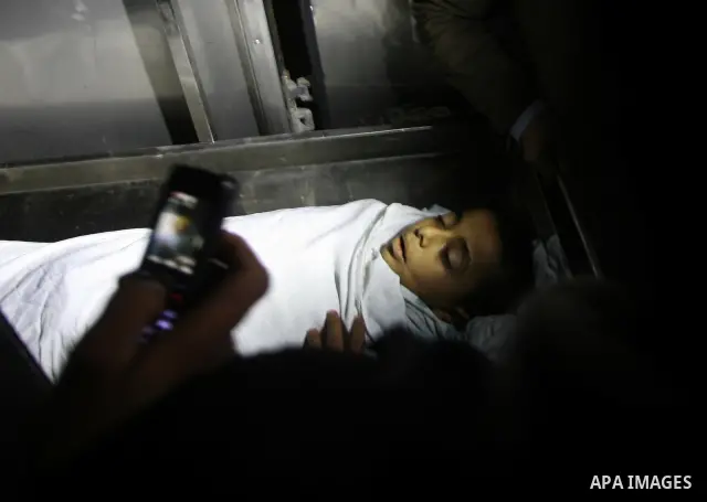 The body of Ramadan al-Zalan, 12, is seen inside the mourgue at al-Shifa hospital in Gaza City on December 9, 201. Al-Zalan was killed after an Israeli air strike. Photo by Mahmud Nassar