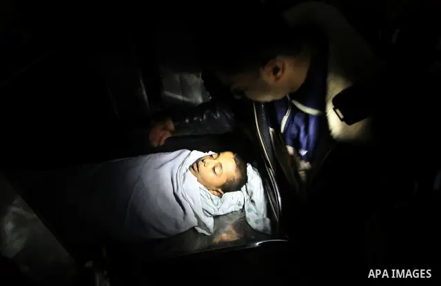 The body of Ramadan al-Zalan, 12, is seen inside the mourgue at al-Shifa hospital in Gaza City on December 9, 201. Al-Zalan was killed after an Israeli air strike. Photo by Mahmud Nassar