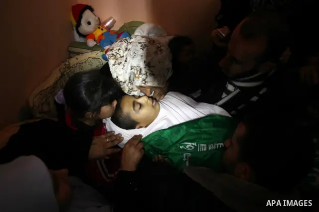 The mother (R) and sister of Palestinian boy Ramadan al-Zaalan, 12, mourn over his body during his funeral in Gaza City on December 10, 2011. Zaalan was killed with his father Bahjat in an Israeli air strike on a civilia...