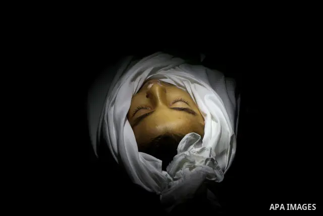 The body of Palestinian boy Ramadan al-Zaalan, 12, lies near mourners during his funeral in Gaza City on December 10, 2011. Zaalan was killed with his father Bahjat in an Israeli air strike on a civilian house in Gaza, m...