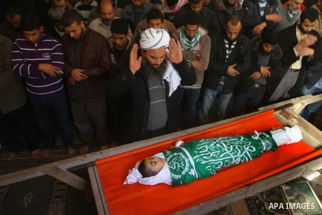 Palestinian mourners perform the prayers on the body of Ramadan al-Zaalan,12, during his funeral in Al Shatea refugee camp in the west of Gaza City on, 10 December 2011. Ramadan was injured yesterday and his father Bahja...
