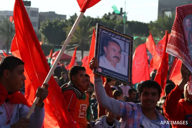 Palestinian supporters of the Popular Front for the Liberation of Palestine (PLFP) wave the group's red flags during a rally held in the northern Gaza Strip town of Beit Lahia on December 10, 2011 to its 44th anniversary...