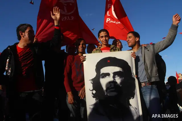 Palestinian supporters of the Popular Front for the Liberation of Palestine (PLFP) wave the group's red flags during a rally held in the northern Gaza Strip town of Beit Lahia on December 10, 2011 to its 44th anniversary...