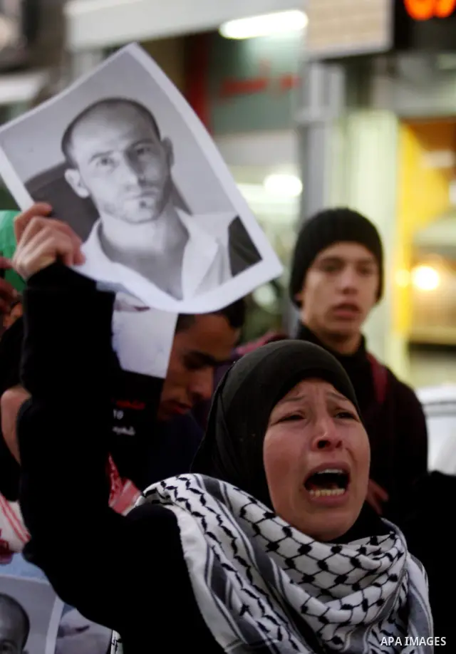 Relatives of Palestinian activist Mustafa Abdelrazek al-Tamimi who died on December 10, 2011 after he was fatally wounded by tear gas the previous day, comfort each other during condolences in the village of Nabi Saleh,...