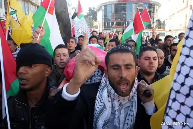 Palestinians carry the body of Mustafa Tamimi during his funeral in the West Bank city of Ramallah, Sunday, Dec. 11, 2011. Tamini, 28, was hurling rocks at an Israeli military vehicle on Friday in the West Bank village o...