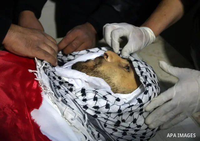 Palestinians prepare the body of Mustafa Tamimi prior to his funeral at a hospital in the West Bank city of Ramallah, Sunday, Dec. 11, 2011. Tamini, 28, was hurling rocks at an Israeli military vehicle on Friday in the W...