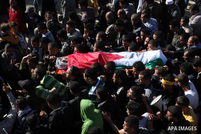 Palestinians carry the body of Mustafa Tamimi during his funeral in the West Bank city of Ramallah, Sunday, Dec. 11, 2011. Tamini, 28, was hurling rocks at an Israeli military vehicle on Friday in the West Bank village o...