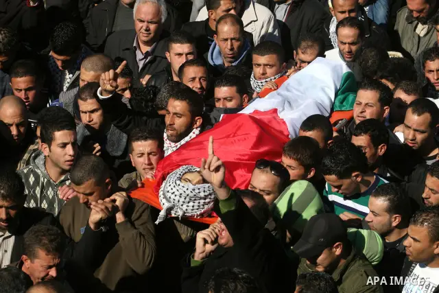 Palestinians carry the body of Mustafa Tamimi during his funeral in the West Bank city of Ramallah, Sunday, Dec. 11, 2011. Tamini, 28, was hurling rocks at an Israeli military vehicle on Friday in the West Bank village o...