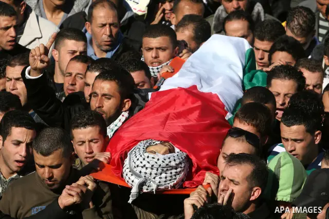 Palestinians carry the body of Mustafa Tamimi during his funeral in the West Bank city of Ramallah, Sunday, Dec. 11, 2011. Tamini, 28, was hurling rocks at an Israeli military vehicle on Friday in the West Bank village o...