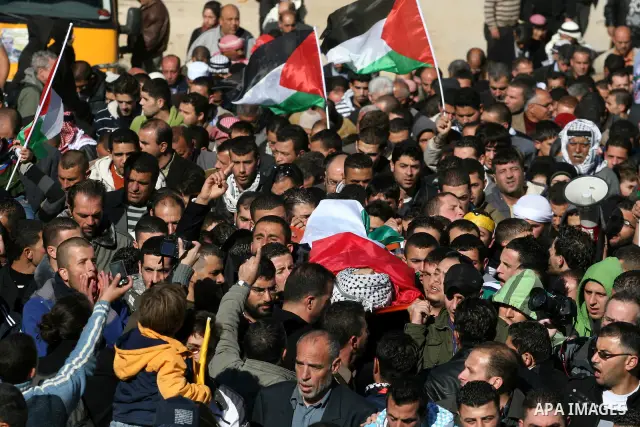 Palestinians carry the body of Mustafa Tamimi during his funeral in the West Bank city of Ramallah, Sunday, Dec. 11, 2011. Tamini, 28, was hurling rocks at an Israeli military vehicle on Friday in the West Bank village o...