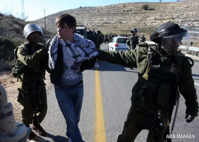 Israeli soldiers detain demonstrators following clashes which erupted after the funeral of Palestinian Mustafa Tamimi in the West Bank town of Nabi Saleh, Sunday, Dec. 11, 2011. Tamimi, 28, was hurling rocks at an Israel...