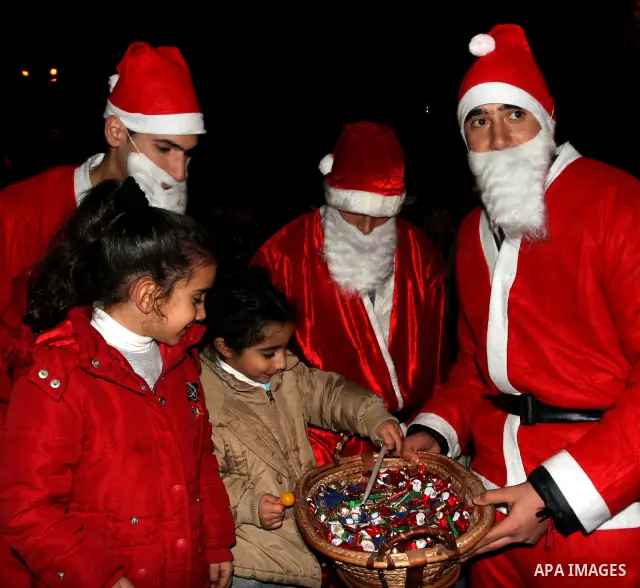 Palestinians light candles during a ceremony for lighting the Christmas tree, in the West Bank City of Ramallah, On Dec.13, 2011. Photo by Issam Rimawi