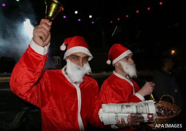 Palestinians light candles during a ceremony for lighting the Christmas tree, in the West Bank City of Ramallah, On Dec.13, 2011. Photo by Issam Rimawi