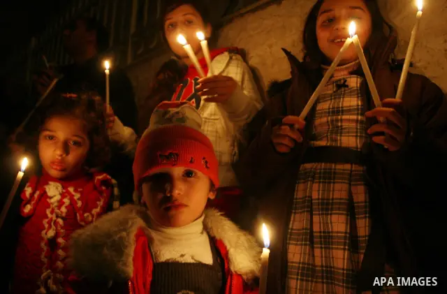 Palestinians Children light candles during a ceremony for lighting the Christmas tree, in the West Bank City of Ramallah, On Dec.13, 2011. Photo by Issam Rimawi