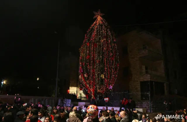 Palestinians light candles during a ceremony for lighting the Christmas tree, in the West Bank City of Ramallah, On Dec.13, 2011. Photo by Issam Rimawi
