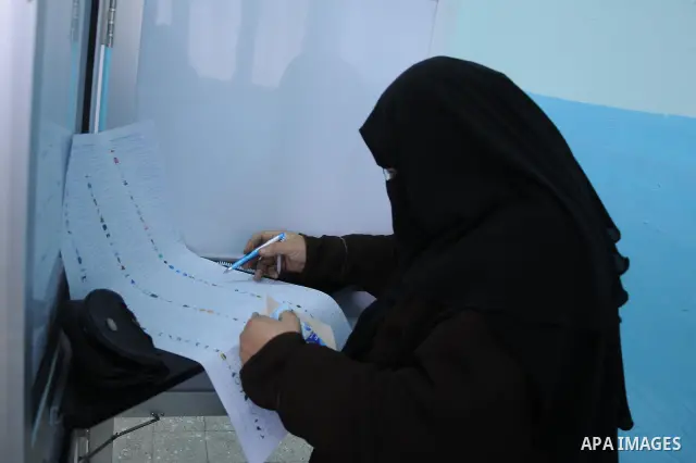 A woman reads a ballot paper before casting his vote at polling station in Giza, southwest of Cairo, on December 14, 2011, during the second stage of Egypt's parliamentary elections. Some 18.8 million Egyptians are eligi...