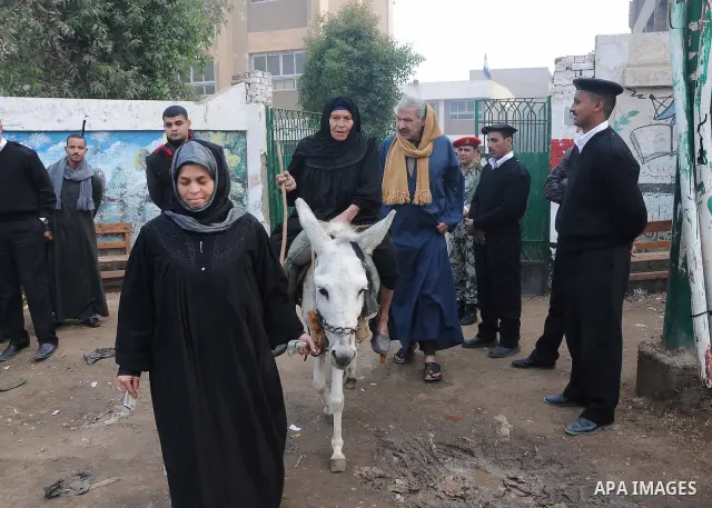 Egyptians wait to vote outside a polling station in Giza, southwest of Cairo, on December 14, 2011, during the second stage of Egypt's parliamentary elections. Some 18.8 million Egyptians are eligible to cast their ballo...
