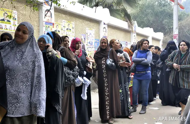 Egyptian women wait to vote outside a polling station in Giza, southwest of Cairo, on December 14, 2011, during the second stage of Egypt's parliamentary elections. Some 18.8 million Egyptians are eligible to cast their...