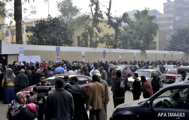 A Egyptians wait to vote outside a polling station in Giza, southwest of Cairo, on December 14, 2011, during the second stage of Egypt's parliamentary elections. Some 18.8 million Egyptians are eligible to cast their bal...