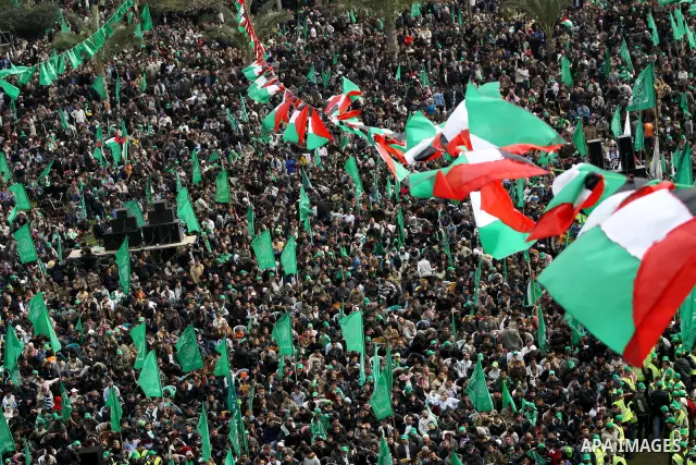 Thousands of Palestinian supporters of Hamas wave the Islamist movement's flags during celebrations for the 24th anniversary of its foundation in Gaza City on December 14, 2011. Photo by Ashraf Amra