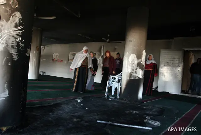 Palestinian women from the West bank village of Burqa near Ramallah, view the damage at the village Al-Nur mosque, on 15 December 2011. The mosque was set on fire during the night allegedly by Israeli settlers and Hebrew...