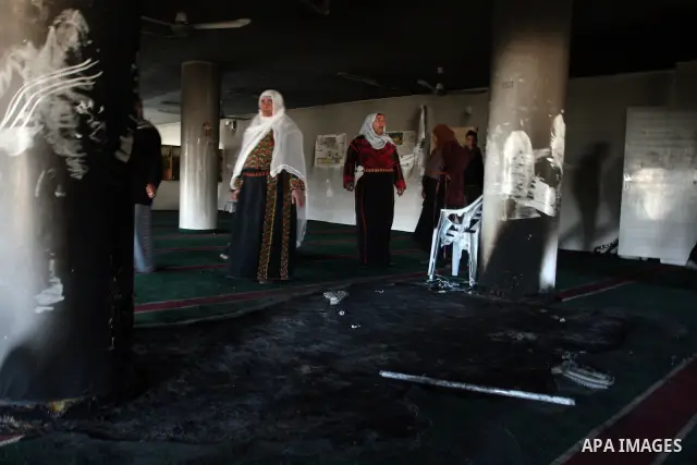 Palestinian women from the West bank village of Burqa near Ramallah, view the damage at the village Al-Nur mosque, on 15 December 2011. The mosque was set on fire during the night allegedly by Israeli settlers and Hebrew...