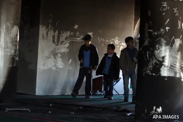 Palestinians from the West bank village of Burqa near Ramallah, view the damage at the village Al-Nur mosque, on 15 December 2011. The mosque was set on fire during the night allegedly by Israeli settlers and Hebrew slog...