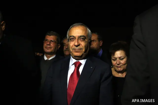 Palestinian prime minister Salam Fayyad watches the lighting of a Christmas tree at Manger Square, outside the Church of the Nativity in West Bank town of Bethlehem,Thursday, Dec. 15, 2011. Christian worshippers began th...