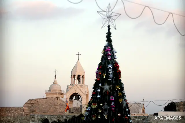 Palestinians watch the lighting of a Christmas tree at Manger Square, outside the Church of the Nativity in West Bank town of Bethlehem,Thursday, Dec. 15, 2011. Christian worshippers began their spiritual preparations ah...