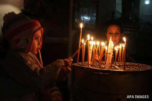 A Palestinian girl lights a candle in the Church of the Nativity, the site revered as the birthplace of Jesus, in the West Bank town of Bethlehem December 15, 2011, ahead of Christmas. Christian worshippers began their s...
