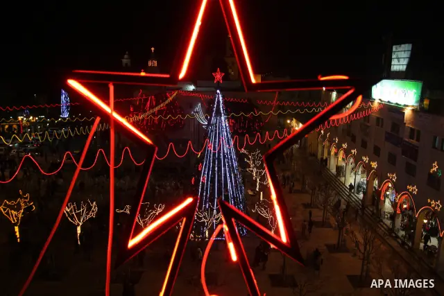 Palestinians watch the lighting of a Christmas tree at Manger Square, outside the Church of the Nativity in West Bank town of Bethlehem,Thursday, Dec. 15, 2011. Christian worshippers began their spiritual preparations ah...