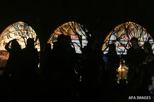 Palestinians watch the lighting of a Christmas tree at Manger Square, outside the Church of the Nativity in West Bank town of Bethlehem,Thursday, Dec. 15, 2011. Christian worshippers began their spiritual preparations ah...