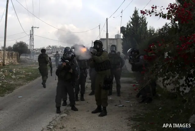 Israeli border police officers clash with Palestinian demonstrators during a protest in the village of Kufr Qaddum near the Israeli settlement of Kdumim, in the northern West Bank, Friday, Dec. 16, 2011. Photo by Wagdi E...