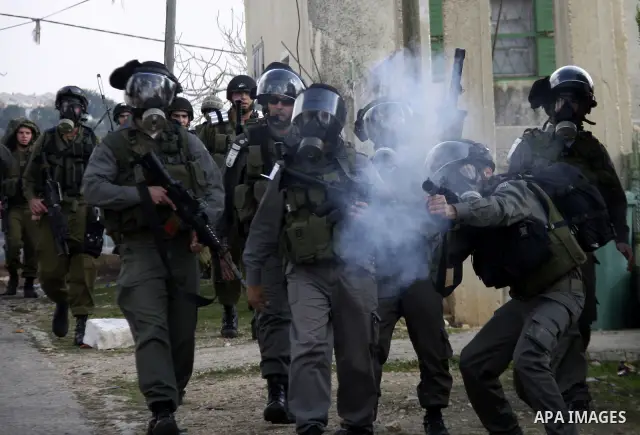 Israeli border police officers clash with Palestinian demonstrators during a protest in the village of Kufr Qaddum near the Israeli settlement of Kdumim, in the northern West Bank, Friday, Dec. 16, 2011. Photo by Wagdi E...