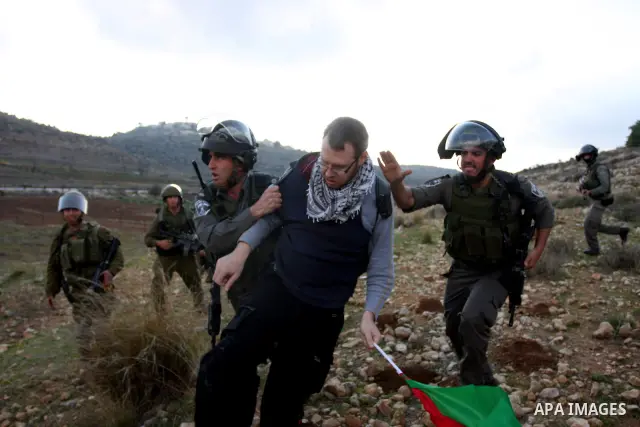 A Palestinian protester is detained by Israeli soldiers during clashes at a weekly protest against a nearby Jewish settlement, in the West Bank village of Nabi Saleh, near Ramallah December 16, 2011. Some 100 demonstrato...