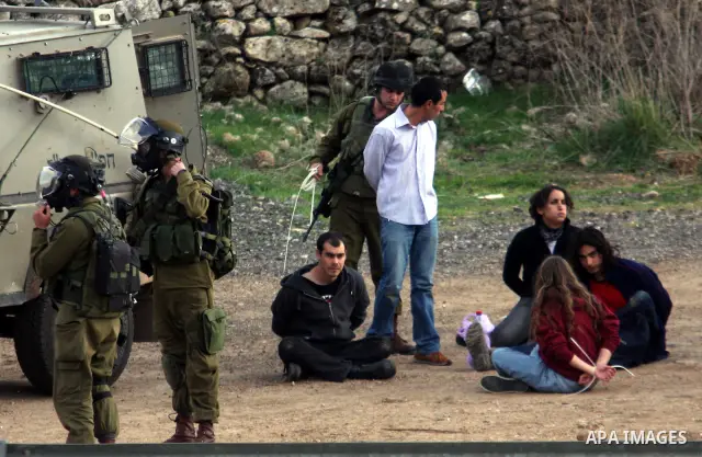 Handcuffed Palestinian protesters sit on the ground after being detained by Israeli soldiers during clashes at a weekly protest against a nearby Jewish settlement, in the West Bank village of Nabi Saleh, near Ramallah De...