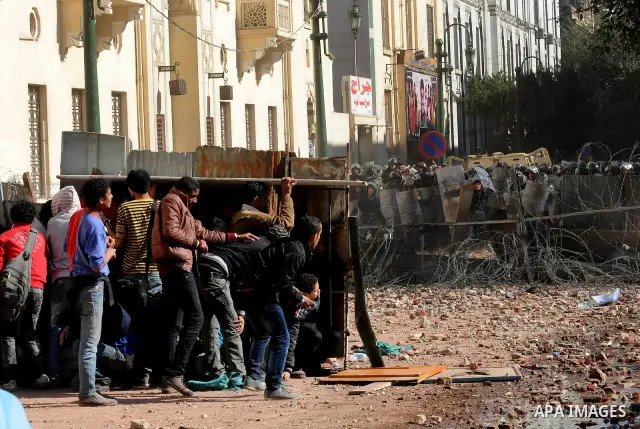 Egyptian protesters throw stones towards security forces during clashes in central Cairo on December 18, 2011 in the third straight day of violence which has left 10 people dead and some 500 wounded. Photo by Ahmed Asad