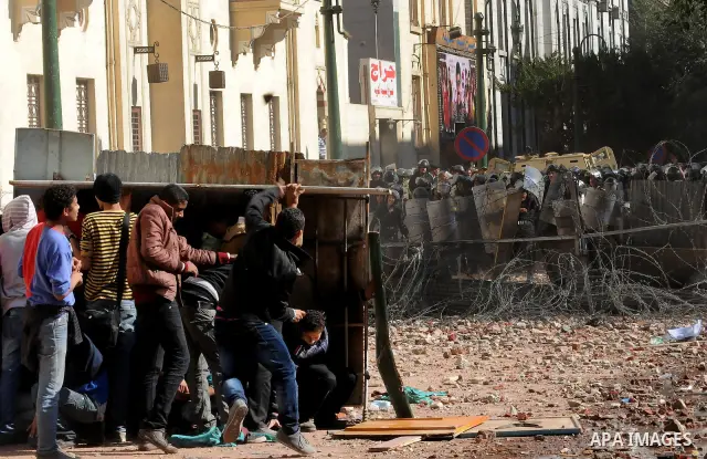 Egyptian protesters throw stones towards security forces during clashes in central Cairo on December 18, 2011 in the third straight day of violence which has left 10 people dead and some 500 wounded. Photo by Ahmed Asad