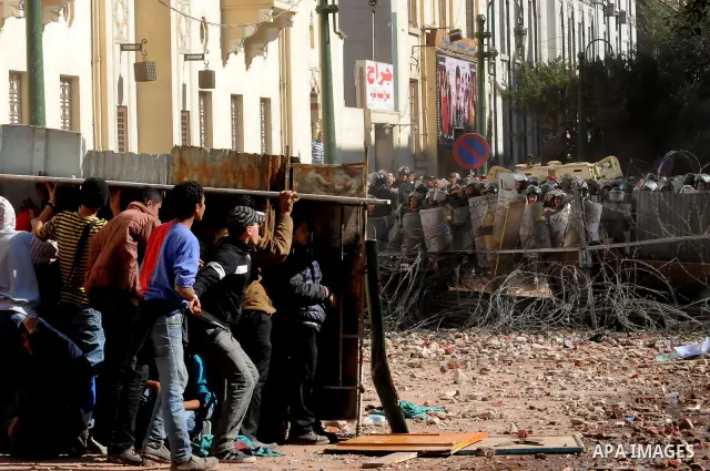 Egyptian protesters throw stones towards security forces during clashes in central Cairo on December 18, 2011 in the third straight day of violence which has left 10 people dead and some 500 wounded. Photo by Ahmed Asad