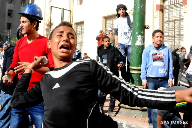 Egyptian protesters throw stones towards security forces during clashes in central Cairo on December 18, 2011 in the third straight day of violence which has left 10 people dead and some 500 wounded. Photo by Ahmed Asad