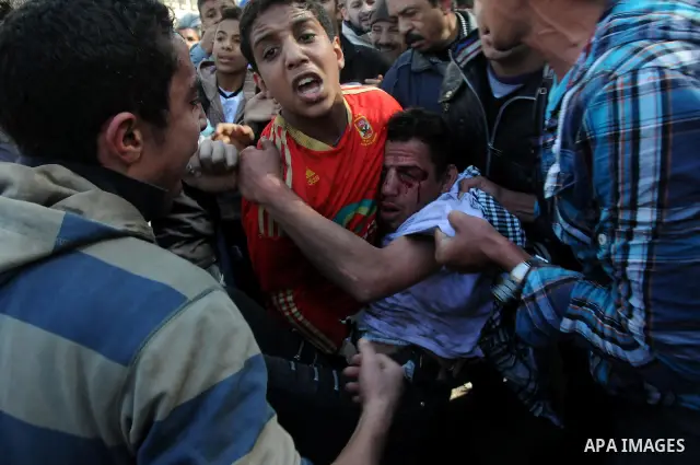 Egyptian medics help a young protester near Tahrir Square in Cairo, Egypt, Sunday, Dec. 18, 2011. Troops and protesters are clashing for the third straight day in Cairo, pelting each other with rocks in skirmishes near p...