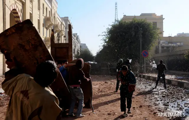 Egyptian protesters throw stones towards security forces during clashes in central Cairo on December 18, 2011 in the third straight day of violence which has left 10 people dead and some 500 wounded. Photo by Ahmed Asad
